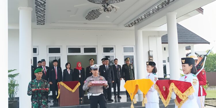 FOTO : DISKOMINFO SANTIK/MATA KALTENG - Pj Bupati Gumas Herson B Aden ketika menyerahkan duplikat bendera pusaka merah putih kepada anggota paskibraka, Kamis, 15 Agustus 2024.