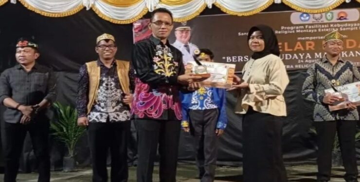 FOTO : IST/MATAKALTENG - Kadisbudpar Kotim Bima Eka Wardana saat menyerahkan penghargaan kepada pemenang lomba, Sabtu 24 Agustus 2024 malam. 