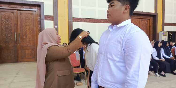 FOTO : DEVIANA/MATAKALTENG - Staf Ahli Bupati Kotim Rusmiati saat mengalungkan tanda peserta, Senin 26 Agustus 2024.