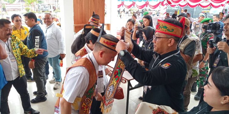 FOTO : KPU GUMAS/MATA KALTENG - Pasangan bakal calon Bupati dan Wakil Bupati Gumas Jaya S Monong dan Efrensia LP Umbing dipasangkan selendang Dayak, ketika akan mendaftar ke kantor KPU setempat, Rabu, 28 Agustus 2024.
