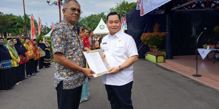 FOTO : DEVIANA/MATAKALTENG - Bupati Kotim Halikinnor saat menyerahkan SK ke Sanggul Lumban Gaol, Jumat 30 Agustus 2024.