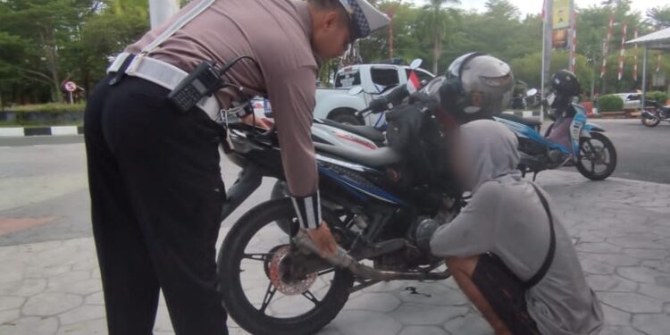 FOTO: MATAKALTENG - Salah seorang pengendara pada saat diminta untuk mengganti knalpot yang tidak sesuai dengan spesifikasi teknis.