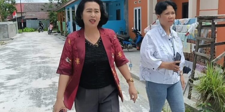 FOTO: IST/MATAKALTENG - Anggota DPRD Kabupaten Gumas Rayaniatie Djangkan (kiri) bersama warga yang tinggal di Perumahan Permata Lestari Kuala Kurun, ketika meninjau pembenahan jalan lingkungan setempat, Jumat 30 Agustus 2024.
