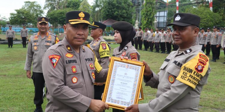 FOTO: MATAKALTENG - Bhabinkamtibmas Kelurahan Panarung, Kecamatan Pahandut, Aiptu Edi Prayitno, pada saat menerima penghargaan Bhabinkamtibmas terbaik, yang diserahkan oleh Kabag Ops Polresta Palangka Raya, Kompol Ganda B Napitupulu.