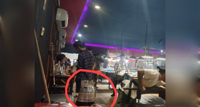 FOTO: MATAKALTENG- Terlihat pengunjung sedang menikmati miras yang dituangkan dalam gelas kaca sambilan main bliar.