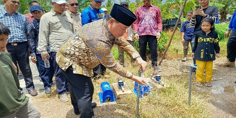 FOTO : DEVIANA/MATAKALTENG - Bupati Kotim Halikinnor saat mencoba mengalirkan air bersih, Minggu 8 September 2024.