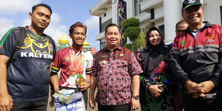 FOTO : DEVIANA/MATAKALTENG - Bupati Kotim Halikinnor saat menyerahkan bonus kepada atlet.