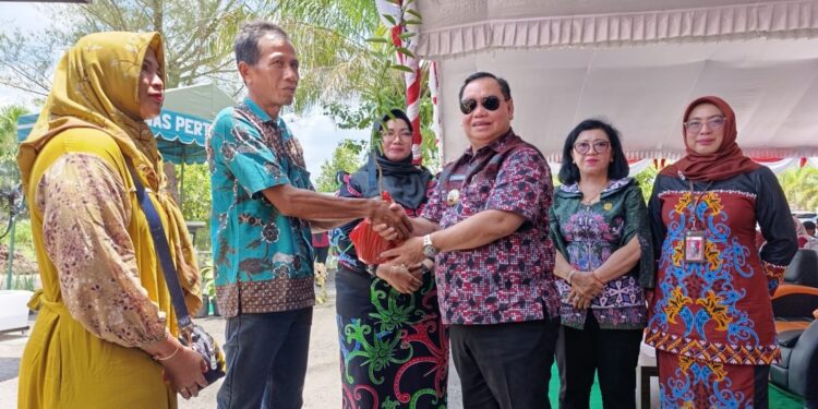 Foto:IST/MATA KALTENG - Penyerahan bantuan alat tanam jagung kepada petani yang dihadiri oleh ketua DPRD Kotim Rinie Anderson (batik hijau).