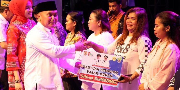 FOTO: PROTOKOL GUMAS/MATA KALTENG - Gubernur Kalteng Sugianto Sabran didampingi Wakil Gubernur Edy Pratowo, dan Pj Bupati Gumas Herson B Aden, ketika menyerahkan bantuan kepada para pendeta, pada kegiatan Kalteng Bermazmur di Kabupaten Gumas, di Stadion Mini Kuala Kurun, Jumat 20 September 2024.