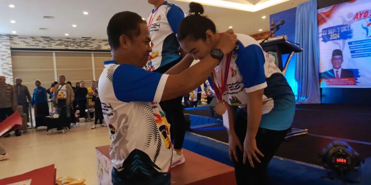 FOTO : DEVIANA/MATAKALTENG - Kadispora Kotim Wiyono saat mengelungkan medali, Minggu 22 September malam.