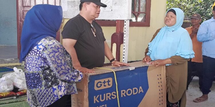 FOTO: DEVIANA/MATAKALTENG - Halikinnor didampingi istrinya saat menyerahkan bantuan kursi roda, beberapa waktu lalu.