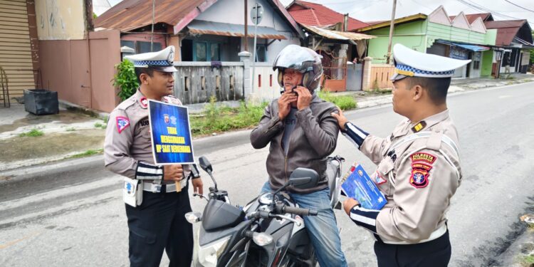 FOTO: MATAKALTENG - Personel Satlantas Polresta Palangka Raya, pada saat mengedukasikan terkait penggunaan helm SNI yang benar kepada salah seorang pengendara.