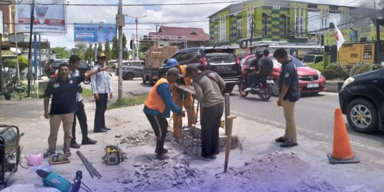 Foto:IST/MATA KALTENG - Pemasangan kembali traffic light bando di persimpangan Jalan HM Arsyad dan Pelita yang sebelumnya mengalami kerusakan lantaran ditabrak truk angkutan alat berat belum lama ini.