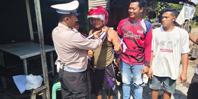 FOTO: MATAKALTENG - Personel Satlantas Polresta Palangka Raya, pada saat mengajarkan warga menggunakan helm yang benar.