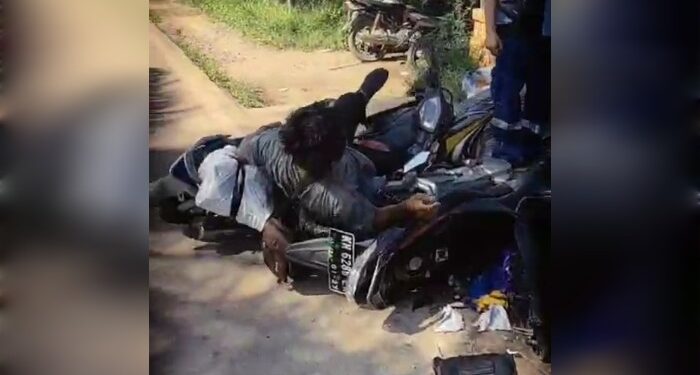 FOTO: IST/MATAKALTENG- Terlihat pengendara motor yang terlibat kecelakaan tergeletak di atas motor.