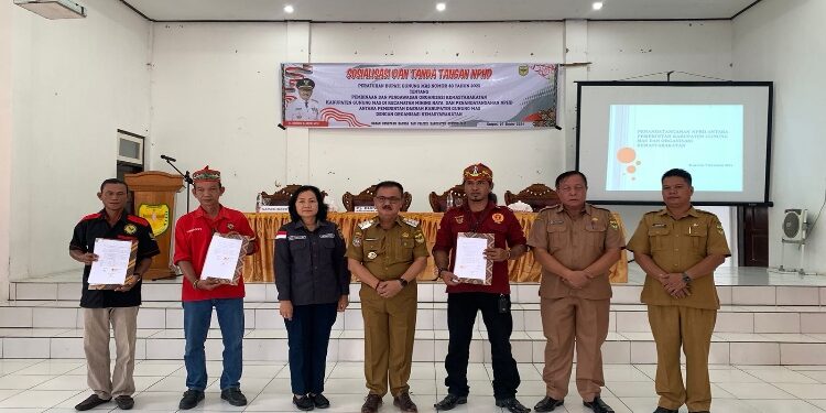 FOTO: DISKOMINFO SANTIK/MATA KALTENG
- Pj Bupati Gumas Herson B Aden bersama pengurus ormas, menunjukkan naskah perjanjian hibah daerah terkait bantuan hibah kepada tiga ormas, di aula kantor Kecamatan Mihing Raya, pekan lalu.
