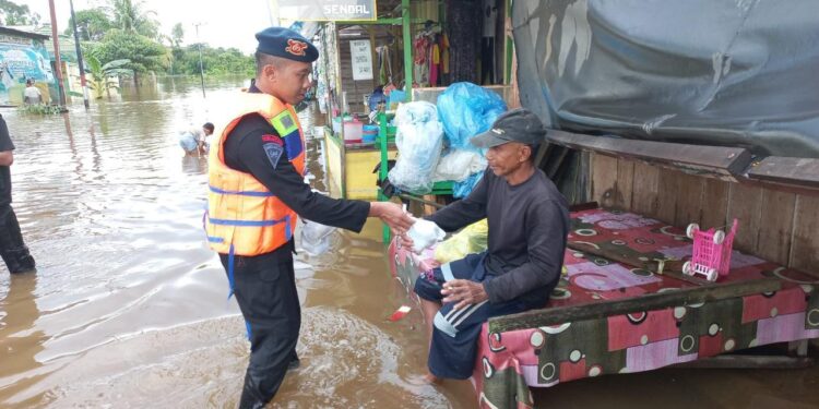 FOTO: MATAKALTENG - Personel Satbrimob Polda Kalteng pada saat menyalurkan bantuan kepada korban banjir.