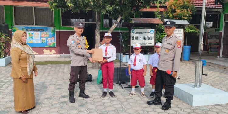 FOTO: MATAKALTENG - Personel Polresta Palangka Raya pada saat menyerahkan hadiah kepada salah seorang siswa.