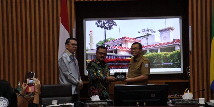 FOTO : DISKOMINFO SANTIK/MATA KALTENG - Pj Bupati Gumas Herson B Aden didampingi Sekda Richard saat menyerahkan plakat kepada Asisten Administrasi Umum Setda Kota Bandung Tono Rusdianto, pada kegiatan kaji tiru pembangunan zona integritas, Selasa, 15 Oktober 2024.