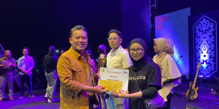 Foto : AKH MATAKALTENG - Pj Bupati Sukamara Rendy Lesmana saat memberikan piala kepada UMKM terbaik saat malam penutupan.