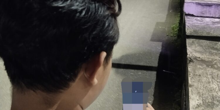 FOTO: IST/MATAKALTENG -Terlihat seorang pemuda di Sampit sedang melihat rekaman video tak senonoh dan mulai tersebar di Kota Sampit, Kotim.