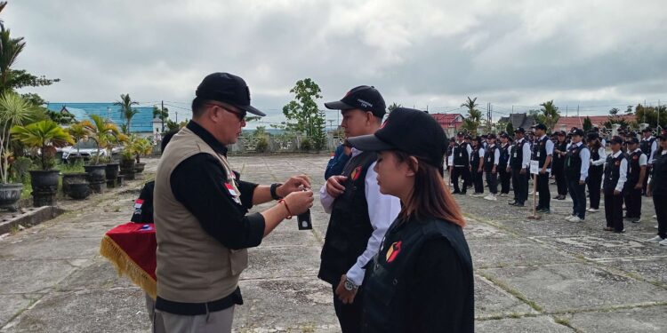 FOTO : BAWASLU GUMAS/MATA KALTENG - Ketua Bawaslu Kabupaten Gumas Yepta H Jinal menyematkan tanda peserta apel siaga pengawasan dalam rangka pengawasan pemilihan Gubernur dan Wakil Gubernur Kalteng serta Bupati dan Wakil Bupati Gumas tahun 2024, di GPU Damang Batu, Kamis, 21 November 2024.