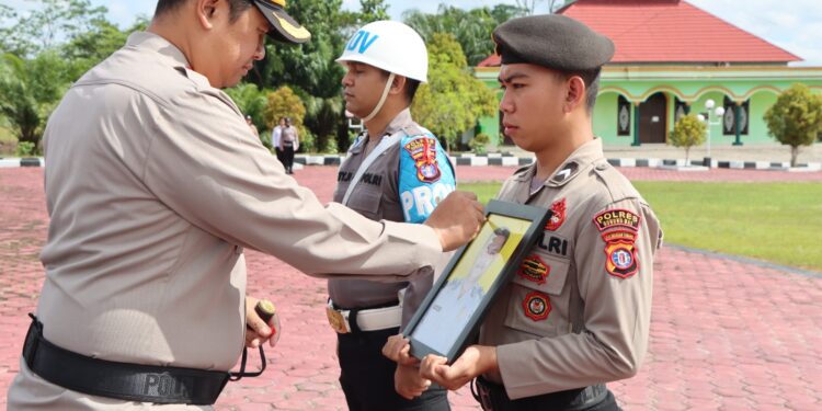 FOTO : HUMAS POLRES GUMAS/MATA KALTENG - Kapolres Gumas AKBP Theodorus Priyo Santosa ketika memberikan tanda silang pada foto anggota polres yang dipecat, Kamis, 21 November 2024.