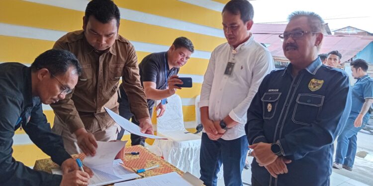 FOTO : DISKOMINFO SANTIK/MATA KALTENG - Pj Bupati Gumas Herson B Aden didampingi Kepala Kantor Bulog Wilayah Kalteng Budi Cahyanto, menyaksikan penandatanganan perjanjian kerjasama antara Kepala Disperindag Supervisi Budi dan kepala perangkat daerah terkait, usai peresmian K-Pingin Mas, di Pasar Baru Kuala Kurun, Jumat, 22 November 2024.