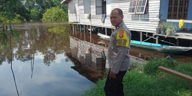 FOTO: MATAKALTENG - Bhabinkamtibmas Kameloh Baru pada saat melakukan pemantauan debit air.