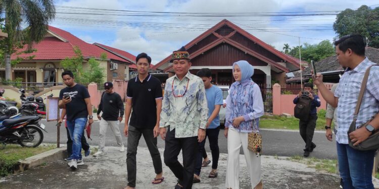 FOTO: MATAKALTENG - Agustiar Sabran bersama istri saat mendatangi TPS 39 di Jalan Kutilang, Kota Palangka Raya, Rabu (27/11/2024).