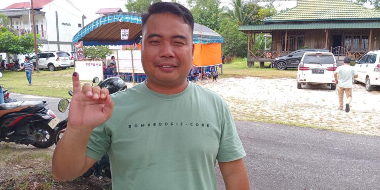 FOTO : DPRD GUMAS/MATA KALTENG - Anggota DPRD Kabupaten Gumas Hermanto ketika menunjukkan jari yang sudah dilumuri tinta, usai mencoblos di TPS 15, Kelurahan Kuala Kurun, Kecamatan Kurun, Rabu, 27 November 2024.