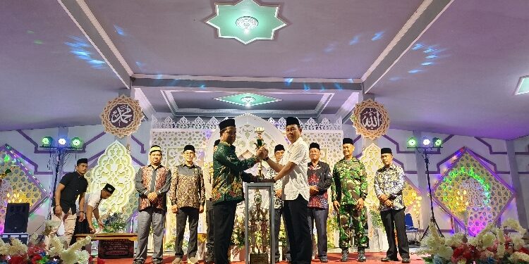 FOTO: IST/MATAKALTENG - Pj Bupati Katingan Sutoyo saat menyerahkan piala bergilir juara umum kepasa Camat Katingan Kuala.