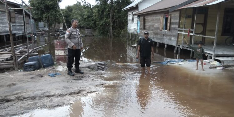 FOTO: MATAKALTENG - Personel Polsek Bukit Batu, pada saat meninjau luapan debit air.