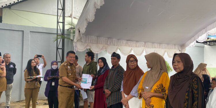 Foto : AKH/MATAKALTENG - Pj Bupati Sukamara Rendy Lesmana saat menyerahkan BLT DBH-DR kepada keluarga penerima manfaat.