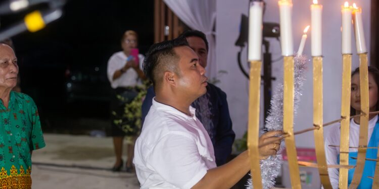FOTO : HERMANTO/MATA KALTENG - Anggota DPRD Kabupaten Gumas Hermanto menyalakan lilin pada ibadah dan perayaan natal jemaat GPT Berkat Iman Kuala Kurun, Selasa, 3 Desember 2024.