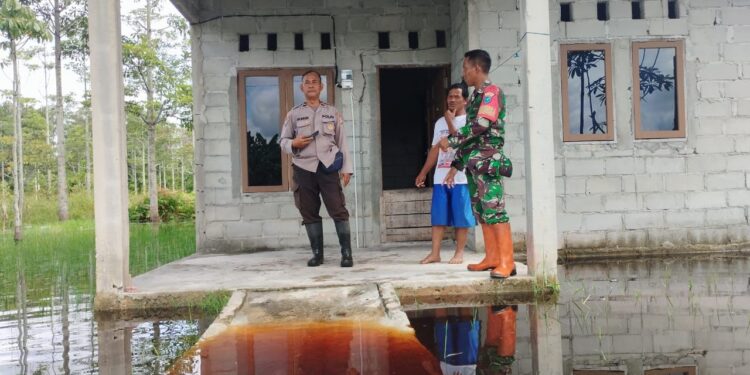 FOTO: MATAKALTENG - Personel Polsek Sabangau, pada saat mengecek debit air di rumah warga.