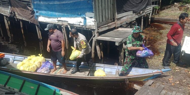 FOTO: MATAKALTENG - Personel Polsek Bukit Batu pada saat menyalurkan bantuan sembako.