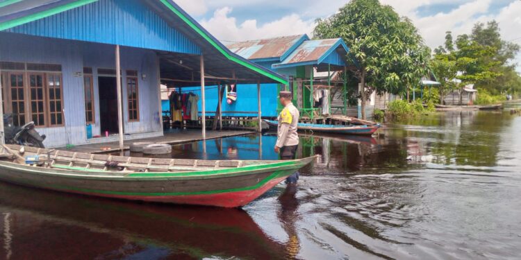 FOTO: MATAKALTENG - Personel Polsek Sabangau, pada saat mengecek debit air di Kelurahan Kameloh Baru.