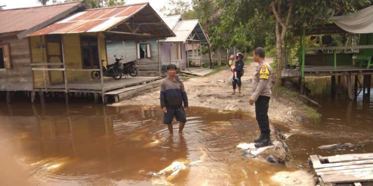 FOTO: MATAKALTENG - Personel Polsek Bukit Batu pada saat mengecek luapan air.