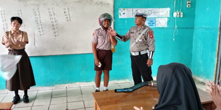FOTO: MATAKALTENG - Personel Satlantas Polresta Palangka Raya, pada saat menyontohkan penggunaan helm yang benar.