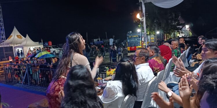 FOTO : DISKOMINFO SANTIK/MATA KALTENG - Artis Ibukota Lulu Chika ketika mengajak Pj Bupati untuk bernyanyi, meski diguyur hujan pada acara malam pergantian tahun, di Taman Kota Kuala Kurun, Selasa, 31 Desember 2024 malam.
