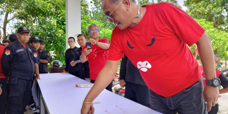 FOTO: MATAKALTENG - Sekretaris DPD PDI Perjuangan Kalteng, Sigit K Yunianto, saat melakukan cap jempol darah, dalam aksi seruan penegakan hukum dan demokrasi di Kantor PDIP Kalteng, Jalan Soekarno, Kota Palangka Raya.