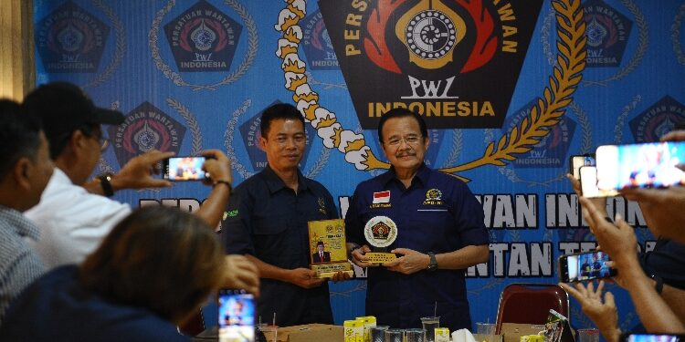 FOTO: OLIVIA/MATAKALTENG - Ketua PWI Kalteng M. Zainal saat bertukar cinderamata dengan Anggota DPD RI, Agustin Teras Narang.