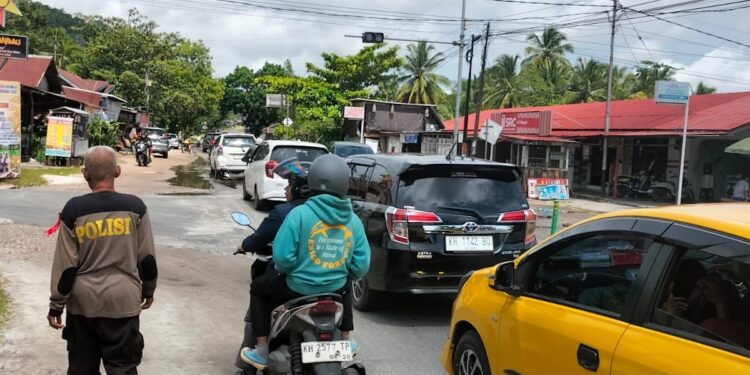 FOTO: MATAKALTENG - Personel Pos Pengamanan Ops Lilin Telabang 2024, pada saat bersiaga mengurai kemacetan.