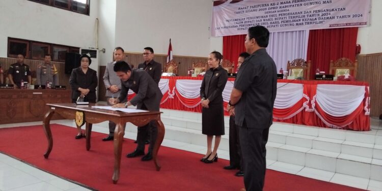 FOTO : DPRD GUMAS/MATA KALTENG - Ketua DPRD Kabupaten Gumas Binartha, Wakil Ketua I DPRD Nomi Aprilia, Wakil Ketua II Espriadi, Bupati dan Wakil Bupati terpilih Jaya Samaya Monong-Efrensia LP Umbing, serta Sekda Richard, ketika menandatangani berita acara pengesahan penyampaian usul hasil pilkada tahun 2024, di ruang rapat paripurna DPRD setempat, Selasa, 14 Januari 2025.
