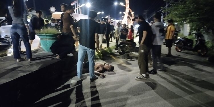 FOTO: AGUS/MATAKALTENG - Nampak pengendara motor genio saat tergeletak usai menghantam trotoar Jalan Cilik Riwut, Kecamatan Baamang, Sabtu 18 Januari 2025 malam.
