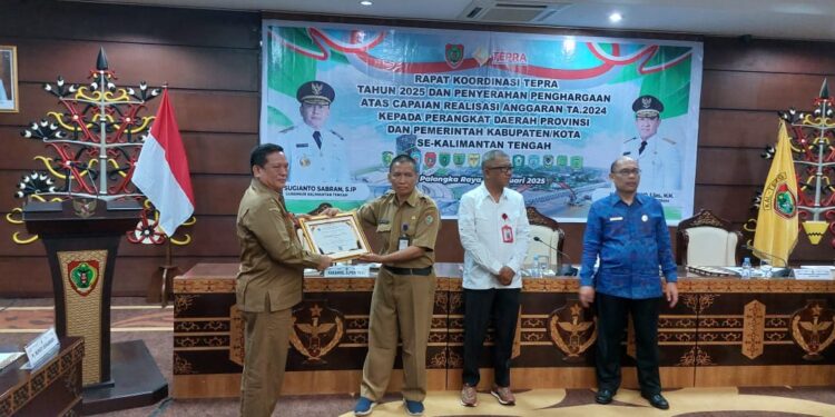 FOTO : DISKOMINFO SANTIK/MATA KALTENG - Pj Bupati Gumas Herson B Aden yang diwakili Staf Ahli Bupati Guanhin, menerima piagam penghargaan sebagai peringkat 3 realisasi DAK non fisik tahun 2024, di Kantor Gubernur Kalteng, Selasa, 21 Januari 2024.
