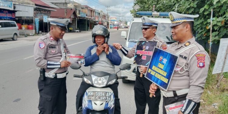 FOTO: MATAKALTENG - Personel Satlantas Polresta Palangka Raya, pada saat meminta pengendara menggunakan helm dengan benar.