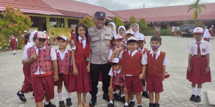 FOTO: MATAKALTENG - Personel Polsek Pahandut, pada saat berfoto bersama siswa SDN 8 Menteng.