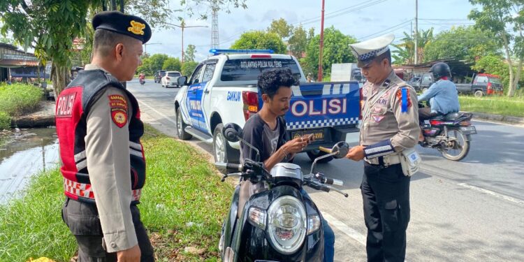 FOTO: MATAKALTENG - Personel Ditlantas Polda Kalteng pada saat menegur pengendara yang tak menggunakan helm.